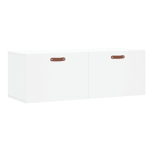 The white wall cabinet shown from a high angle with two doors and brown leather handles