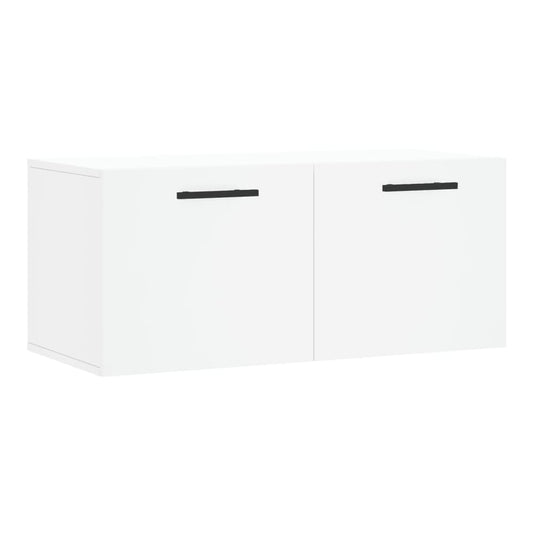The white wall cabinet with two doors and black handles against a plain background