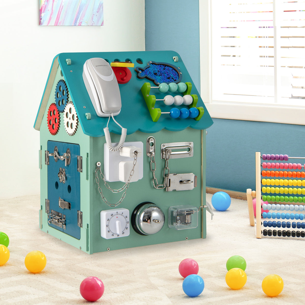 The learning toy standing on a carpeted floor surrounded by colourful plastic play balls