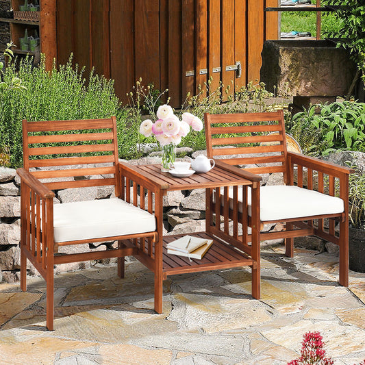 The patio furniture set placed on a stone patio in a garden with flowers on the table