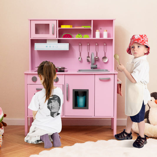 Children playing with the pink wooden play kitchen set, one child at the sink and another standing nearby