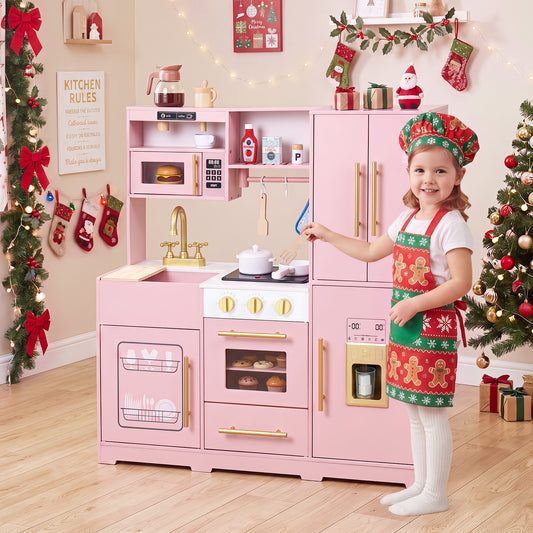 A young girl in a festive apron and hat plays with the pink play kitchen set