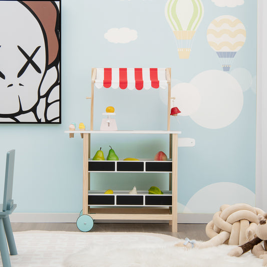 The play kitchen set in a child's room with a large cartoon face picture on the wall