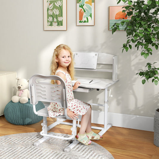 The grey kids study table and chair set with a girl sitting at it in a room