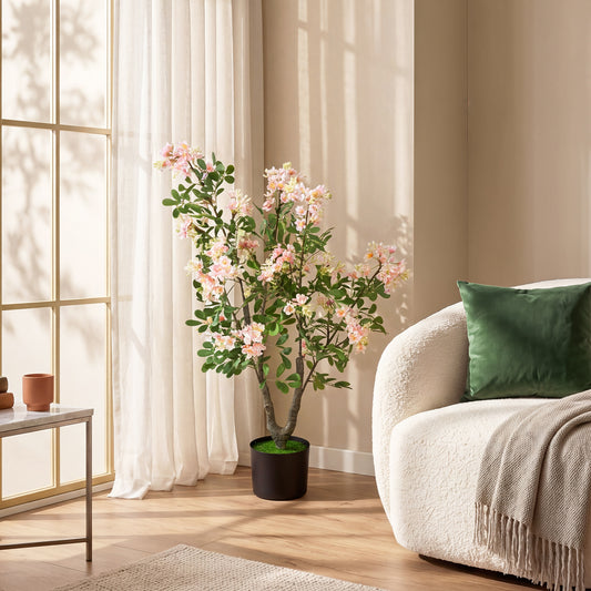 The faux plant placed in a bright living room next to a cream armchair and a window