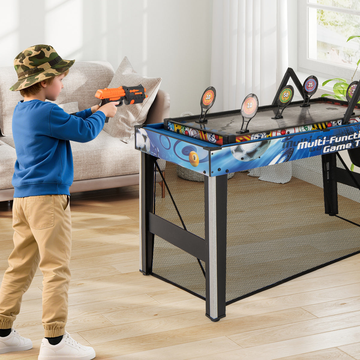 Boy aiming a toy gun at targets on the multi-game table in a home environment