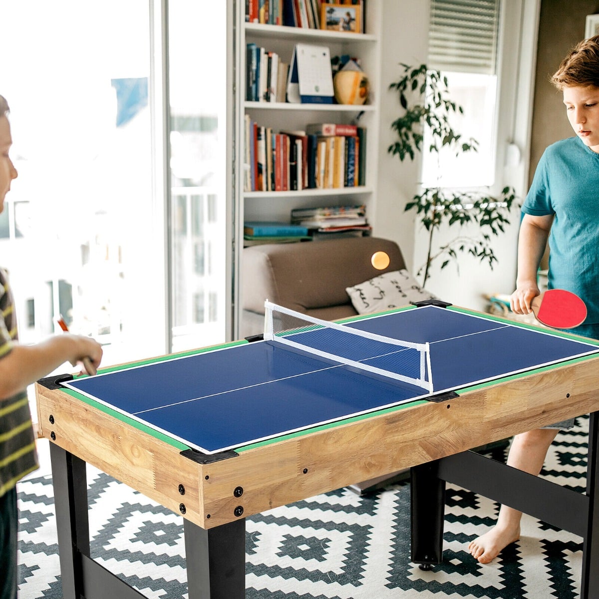 The game table being used for a table tennis match by two children