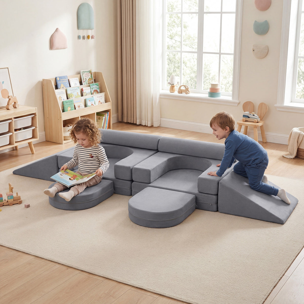 The soft play set in a bright nursery with two children playing on the grey foam cushions