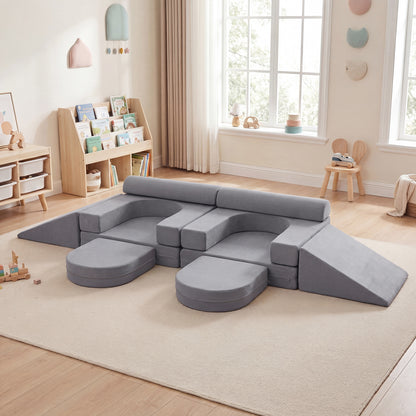 The soft play set arranged as a large grey seating area on a rug in a child's bedroom