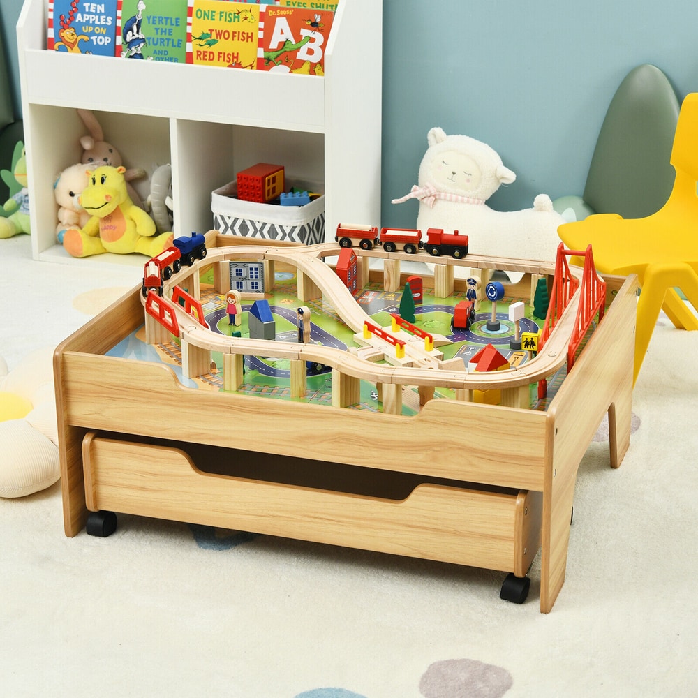 The wooden train railway track set table set up in a child's bedroom with toys