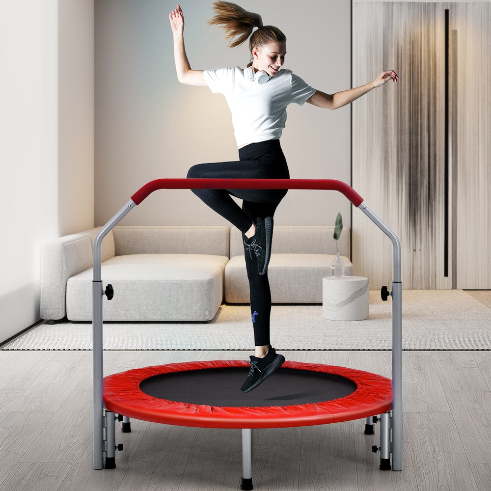 A woman jumping on the red trampoline in a living room