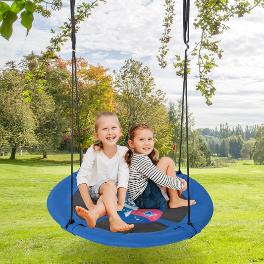 Two smiling young girls sitting on the blue saucer tree swing in a garden setting