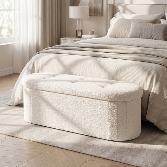 The oval ottoman is placed at the foot of a bed in a bedroom setting