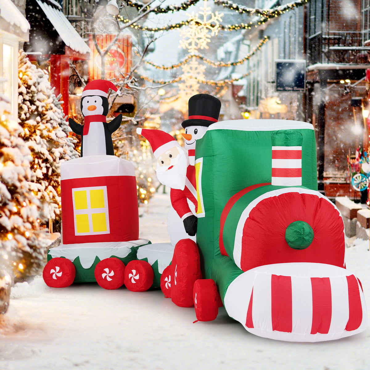 Christmas inflatables train with Santa, snowman and penguin in a snowy street setting