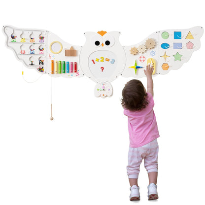 Rear view of a child reaching for the owl activity centre on the wall