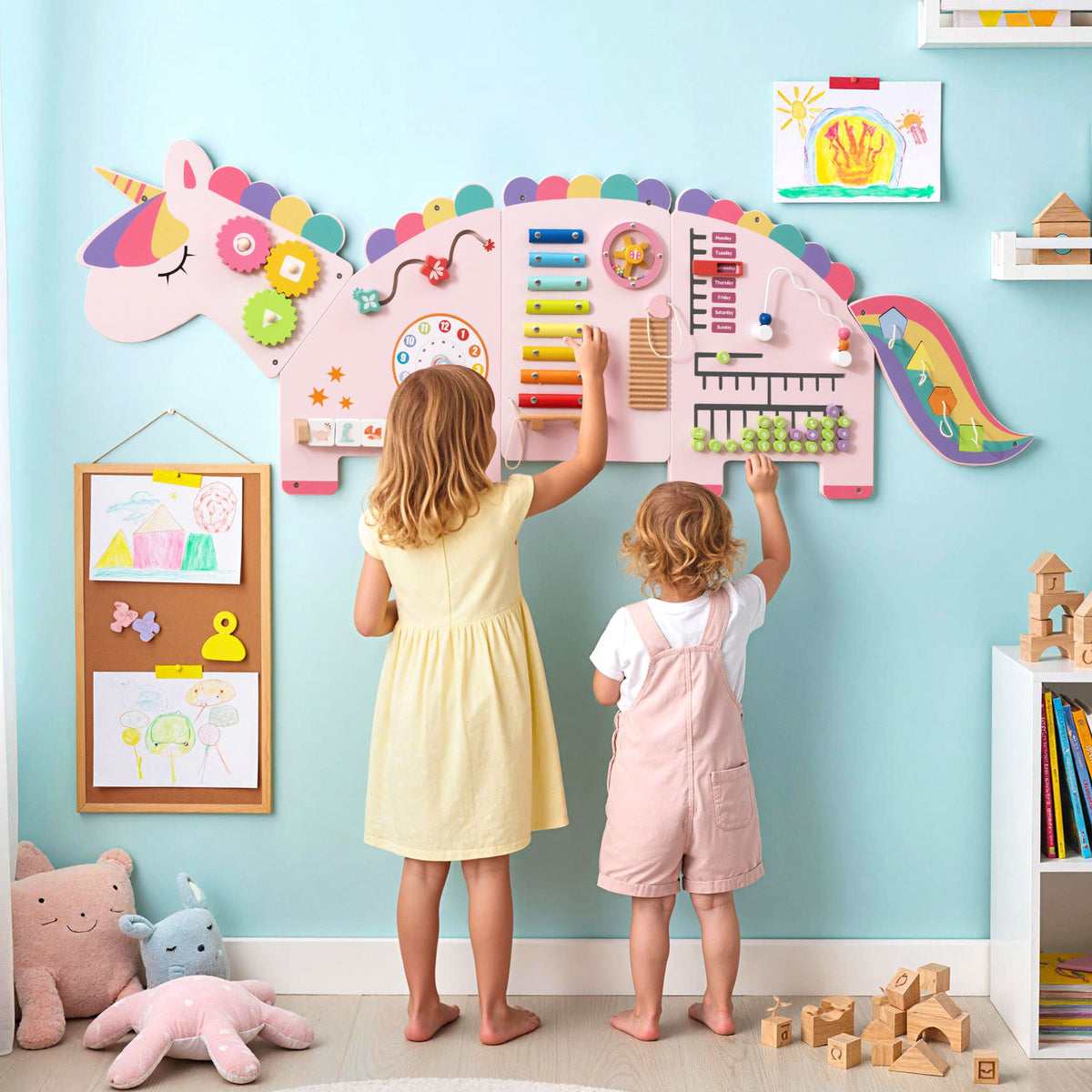Two young children playing with the unicorn activity wall busy board panels