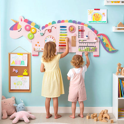 Two young children playing with the unicorn activity wall busy board panels