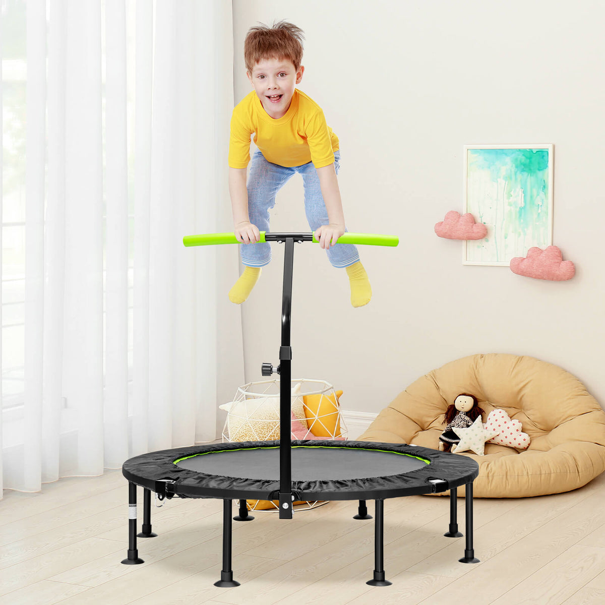 The green mini trampoline with adjustable handrail is set up in a living room with a child bouncing