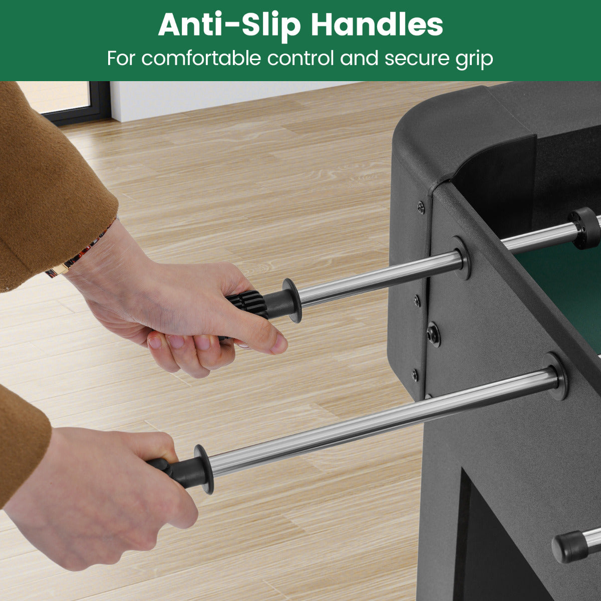 the soccer game table close up showing hands gripping the textured black handles