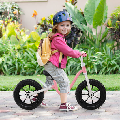 A child wearing a helmet riding the balance bike on a paved path in a garden