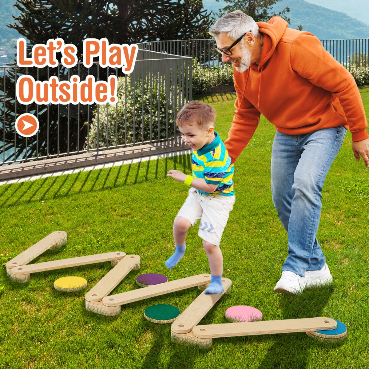 An adult and a child using the wooden balance beam set on a grassy lawn outdoors