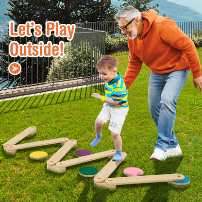 An adult and a child using the wooden balance beam set on a grassy lawn outdoors