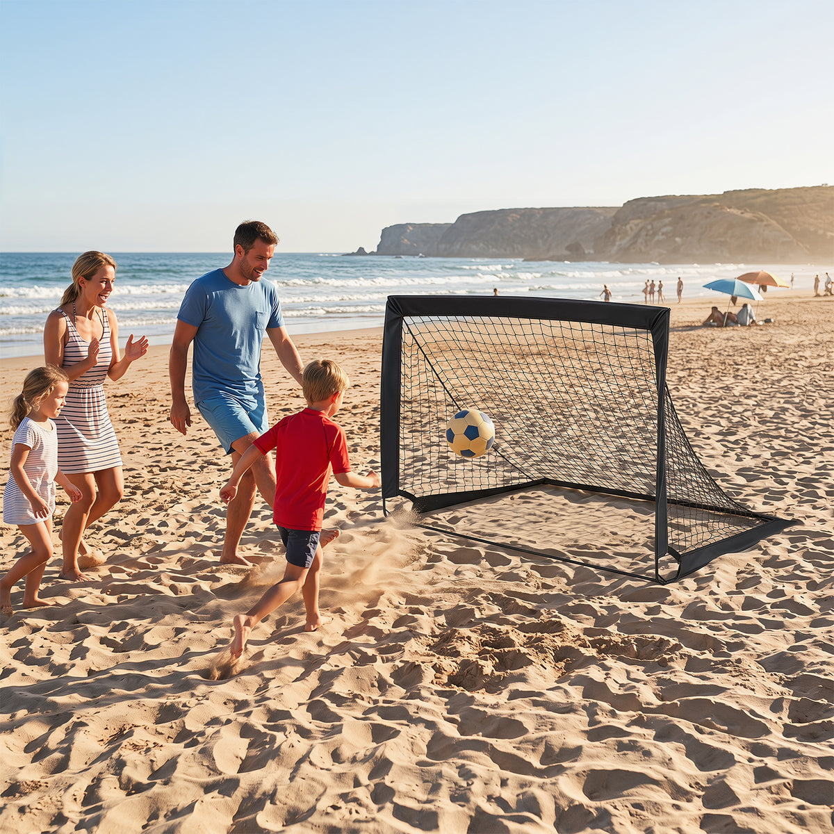 Family playing football with a pop up goal on a sandy beach