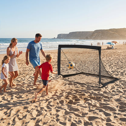 Family playing football with a pop up goal on a sandy beach