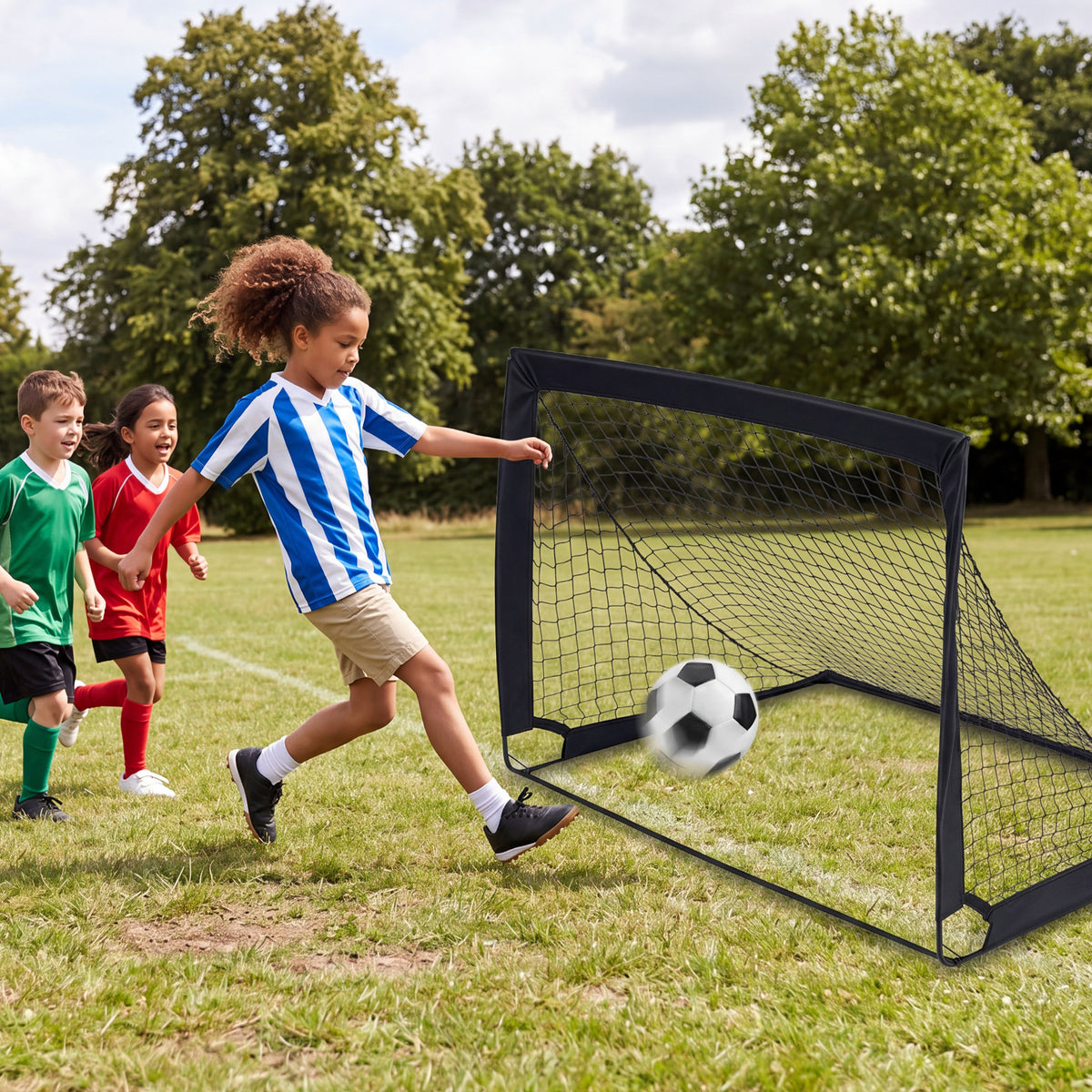 Two children playing football with a pop up goal on grass