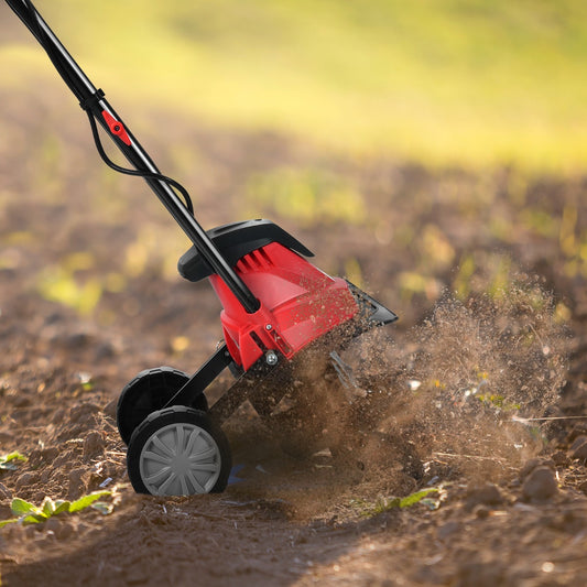 The electric garden tiller churning soil with its blades spinning