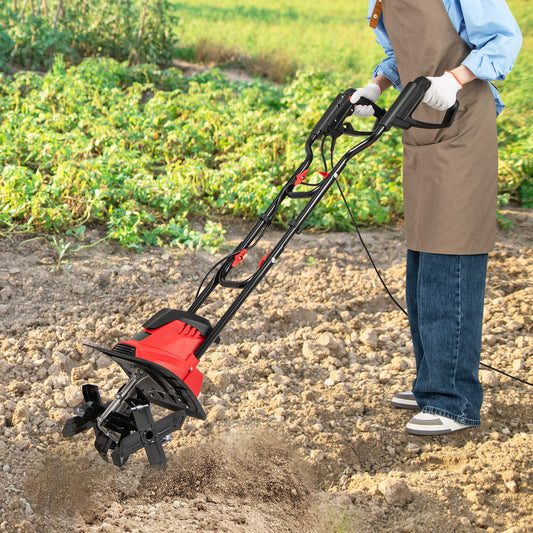 The garden rototiller being used by a person in an apron to cultivate soil in a vegetable patch