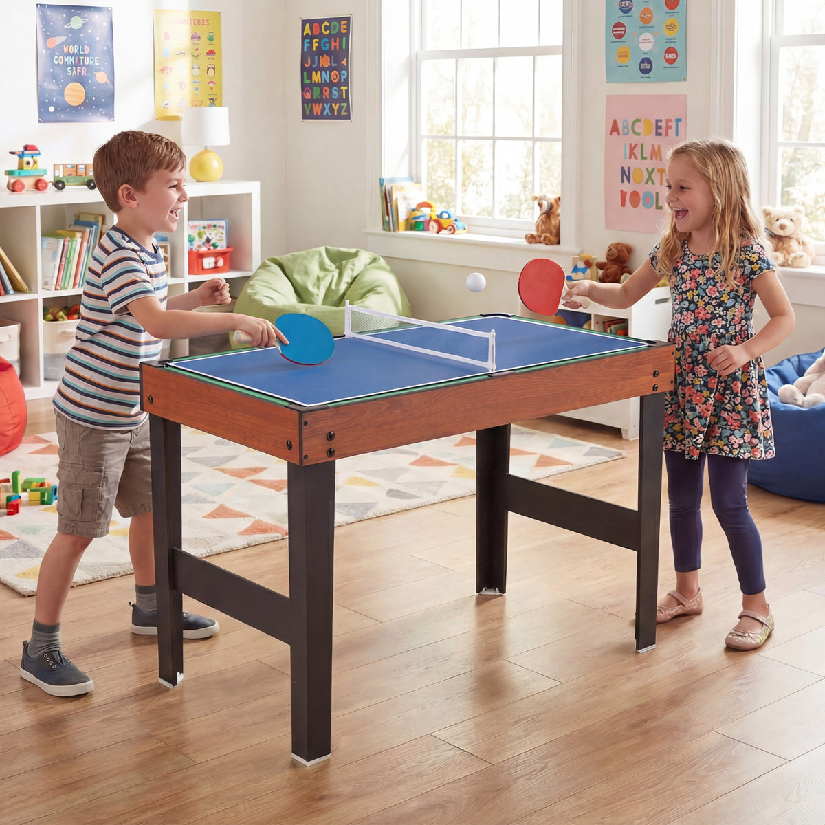 Children playing table tennis on the multi games table in a playroom
