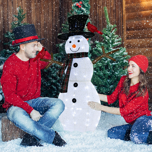 The large pre-lit snowman ornament is shown with two adults in a snowy setting
