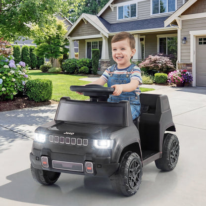 Young boy happily driving the black electric jeep in a driveway