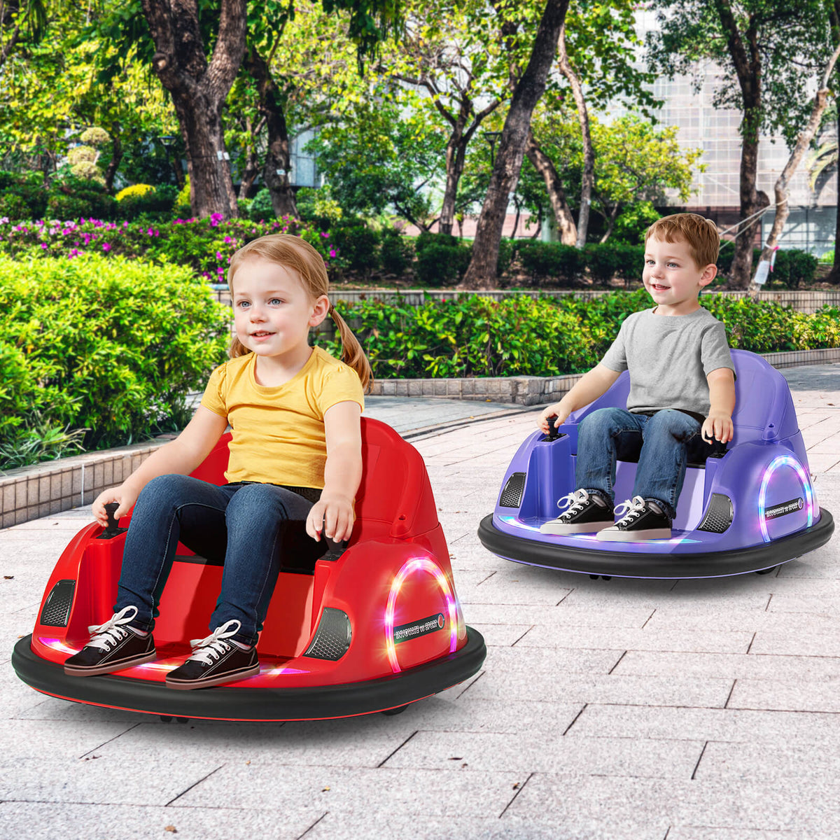 A red and a purple kids electric bumper car being driven by children on a paved outdoor path