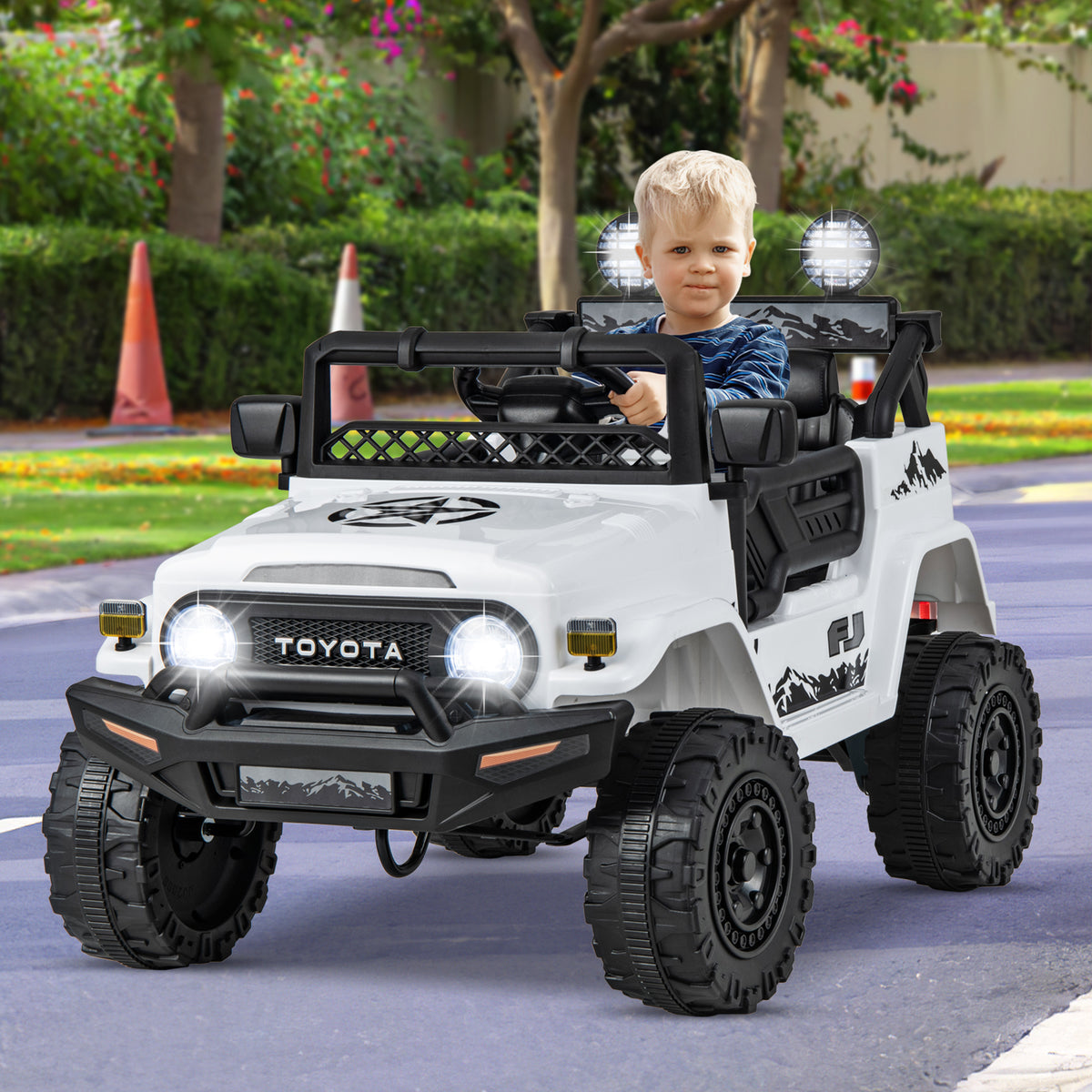 The kids electric car being driven by a young child on a paved path in a park setting