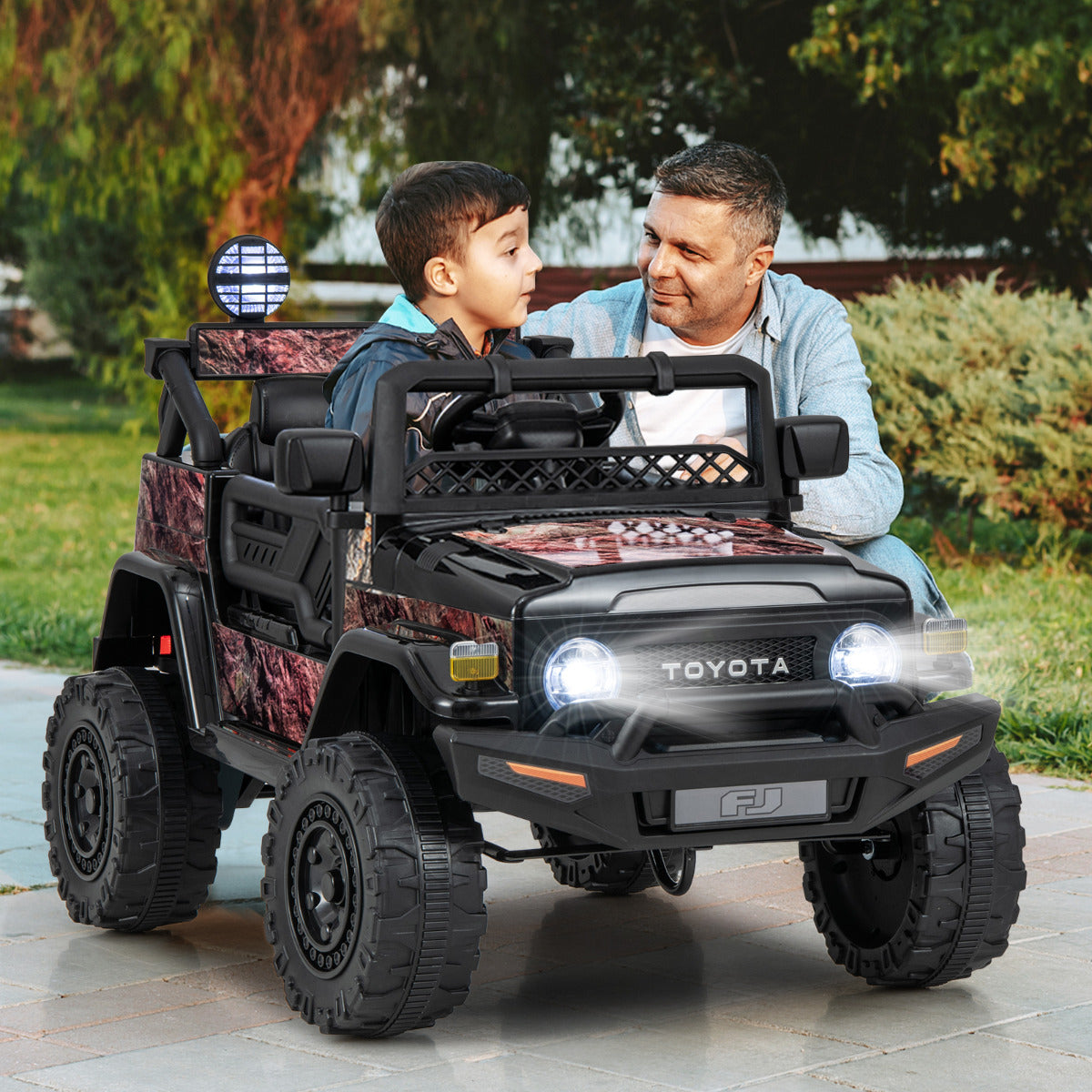 Father and son enjoying a ride in the kids electric car on a paved path