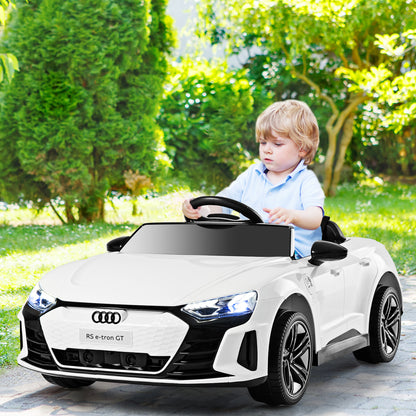 A young boy drives the white kids electric car in a garden setting