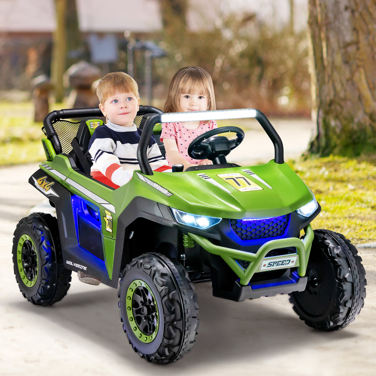 A green kids electric car with two children riding in it on a paved path outdoors