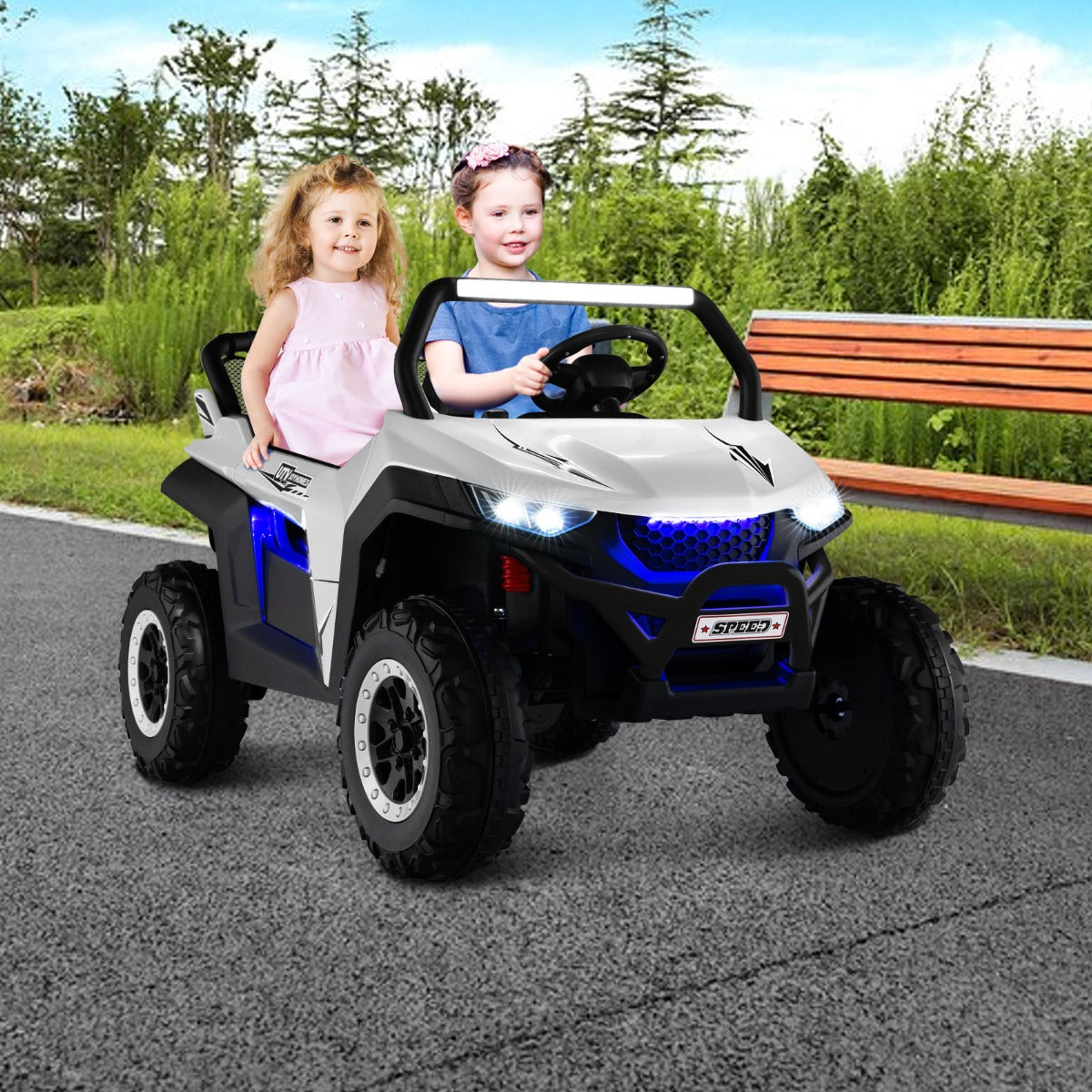 Two children enjoying a ride on the white electric UTV outdoors on a paved path