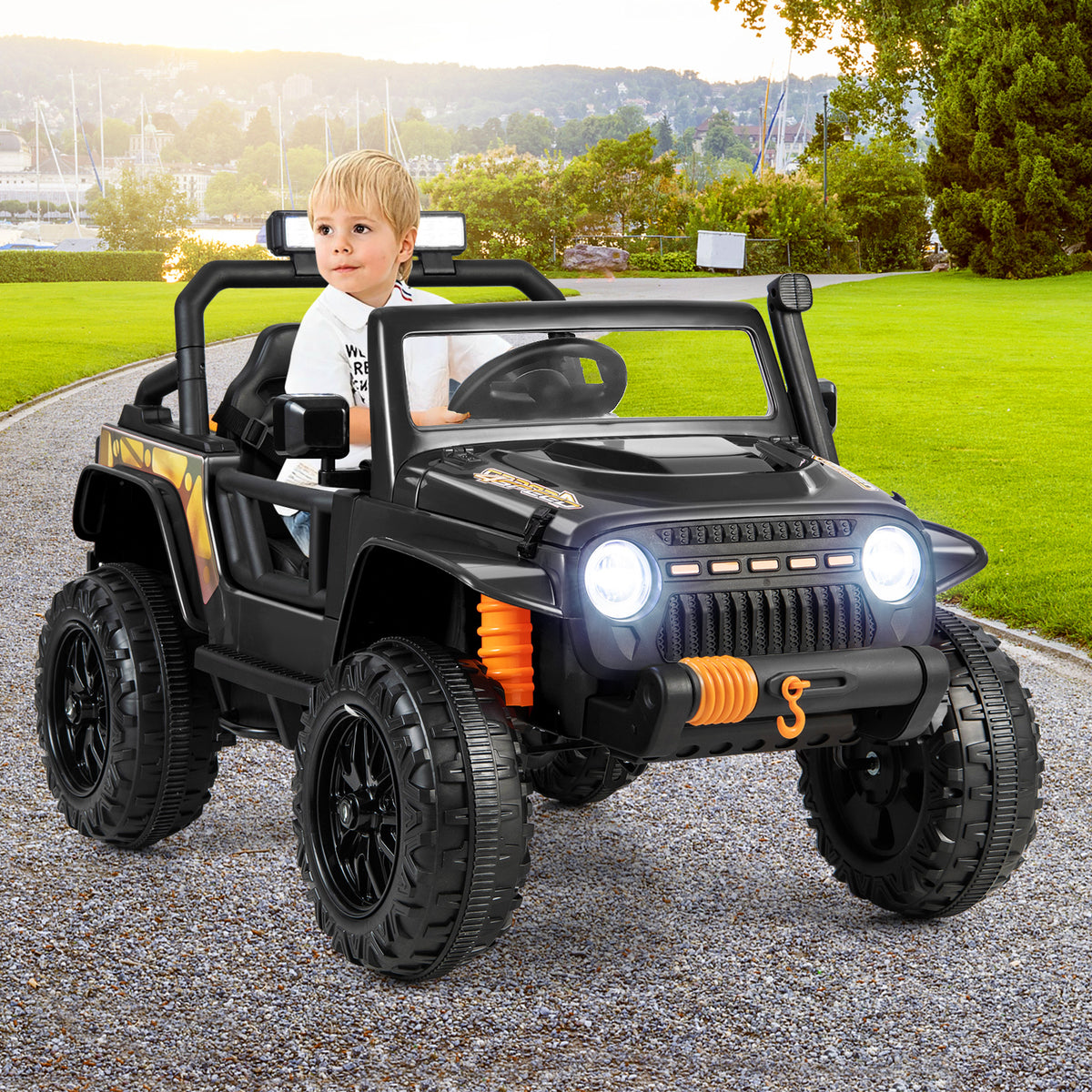 Child driving the black kids electric car on a paved path outdoors