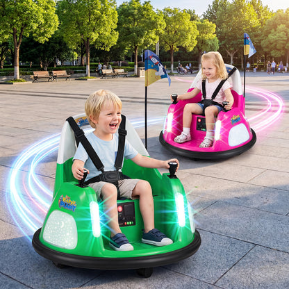 Two children enjoying a ride in the green and pink electric bumper cars outdoors