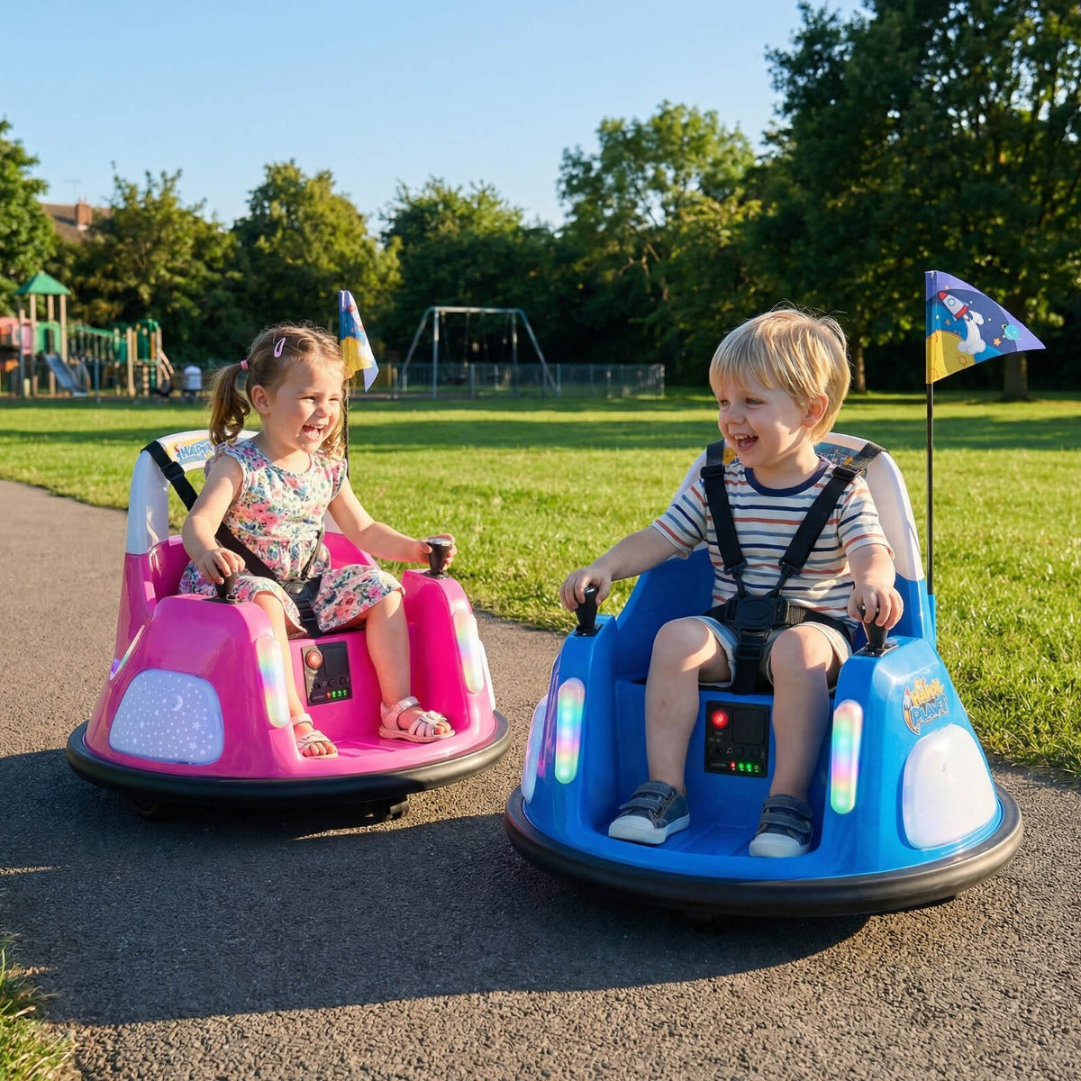 Two children enjoying a ride on pink and blue electric bumper cars in a park
