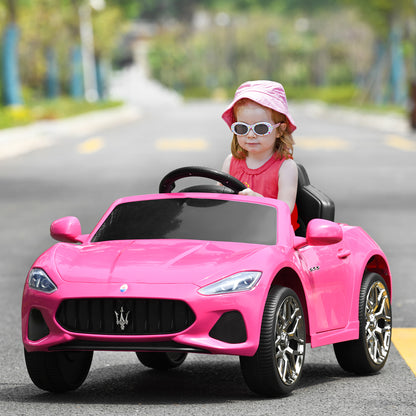 A young girl wearing a pink hat and sunglasses driving the pink kids electric car on a road