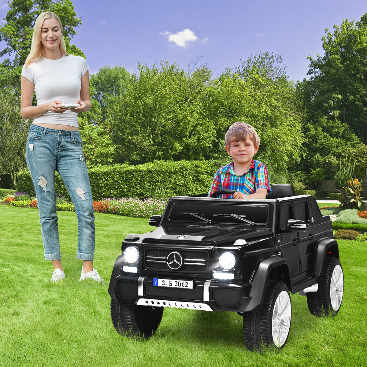 A woman and a boy stand by the black electric car in a garden setting
