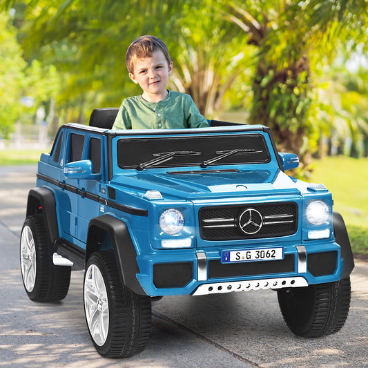 The kids electric car being driven by a young boy on a paved path in a sunny park