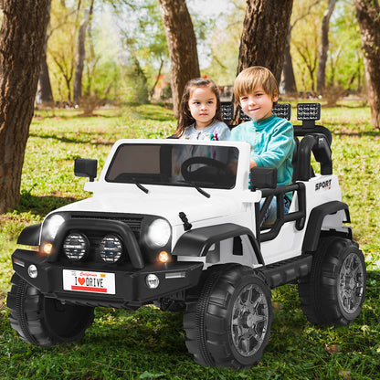 Children enjoying a ride in the white electric truck outdoors in a park setting