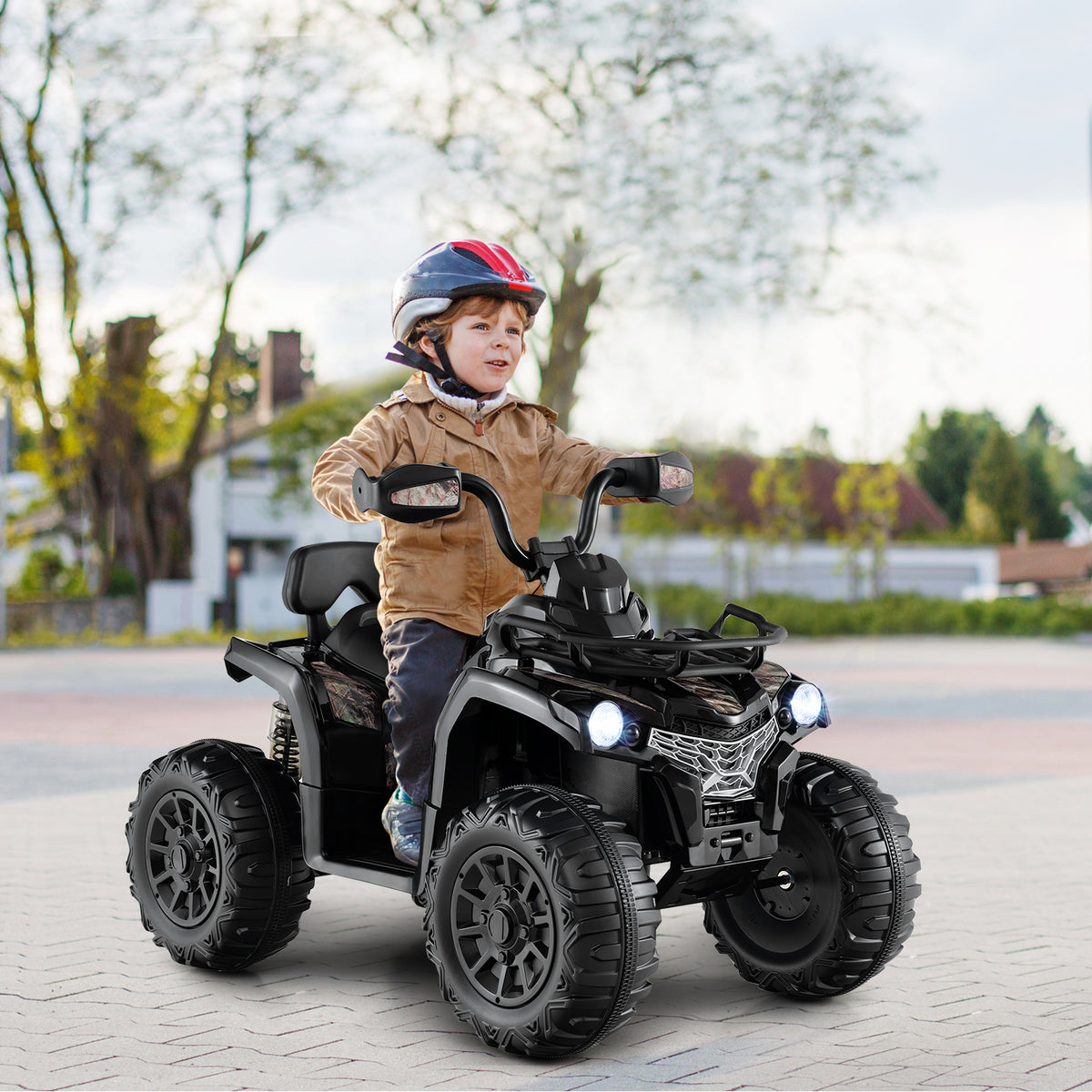 A young boy wearing a helmet happily riding the black kids electric quad bike