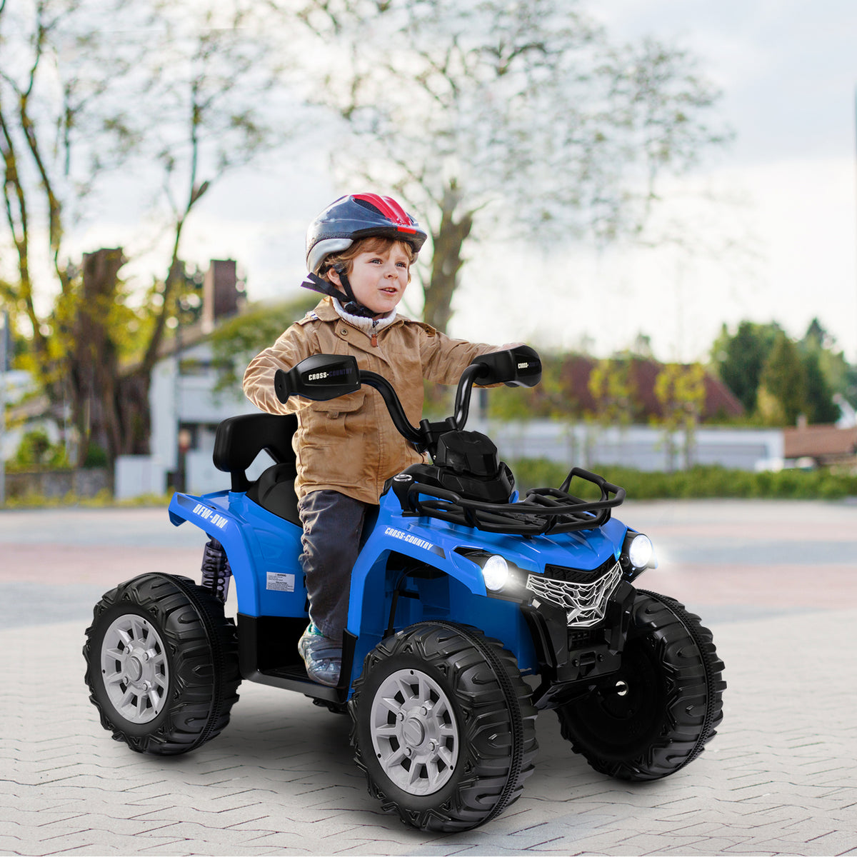 Young boy wearing a helmet riding the blue kids electric quad bike on a paved surface