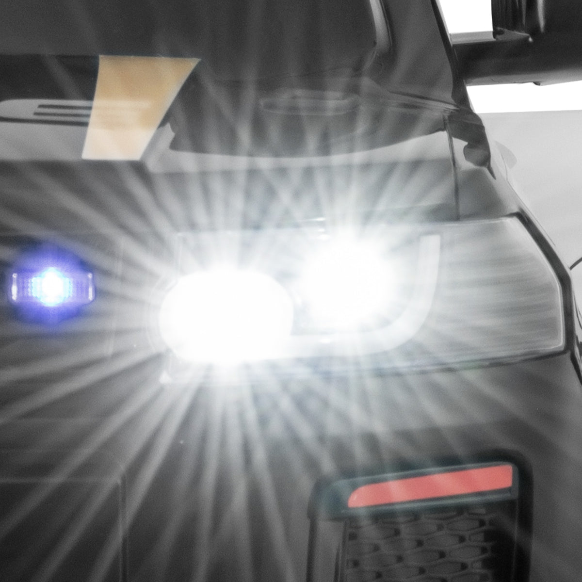 12V Kid Ride on Police Car, the kids electric car showing a close-up of the bright white LED headlight shining